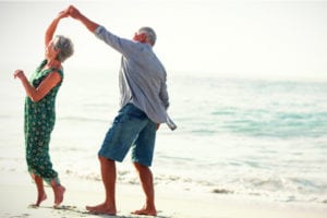 Retired couple dancing on a beach